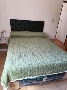 een slaapkamer met een bed met een groen dekbed bij El Parque in San Luis