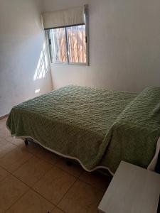 een slaapkamer met een groen bed en een raam bij El Parque in San Luis