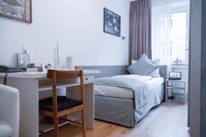 a small bedroom with a bed and a desk with a desk at Stadt-gut-Hotel Rheinischer Hof in Essen +67 photos