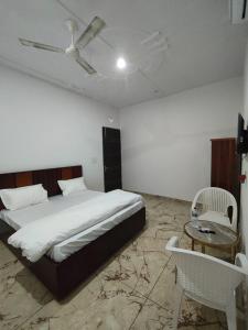 Un dormitorio con una cama y un ventilador de techo. en Yashdeep Hotel, en Jāmb