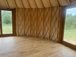 Zimmer mit einem großen Fenster und Holzboden in der Unterkunft Jurajskie Jurty in Golczowice