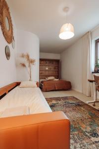 Villa Tapadla في Tąpadła: غرفة نوم بسرير برتقالي وسجادة كبيرة