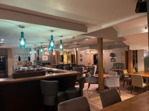 a bar in a restaurant with tables and chairs at Cock O' Barton in Coddington
