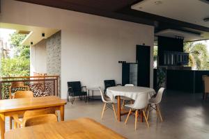 a dining room with a white table and chairs at Hi Cube Hostel in Canggu