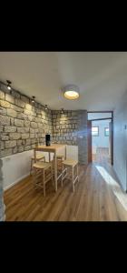Una mesa y sillas en una habitación con una pared de piedra. en לוריא יוקרה בעתיקה, en Safed