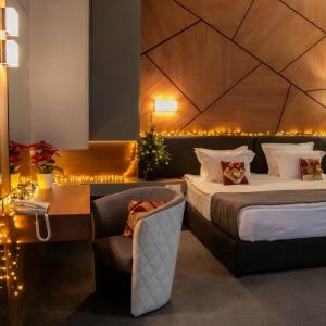 a hotel room with two beds and a chair at Aqua Hotel in Varna City