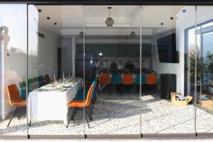 una sala da pranzo con tavolo bianco e sedie arancioni di Armonia de pe lac a Buzău