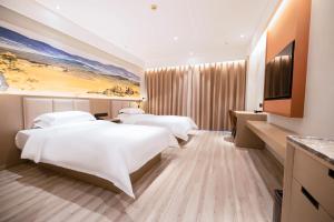 a hotel room with two beds and a television at Qingdao Likelai Garden Hotel in Qingdao
