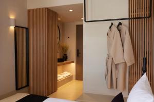 Un dormitorio con una cama y un armario con toallas. en Hotiday Mykonos South Coast, en Mykonos ciudad 7 fotos más