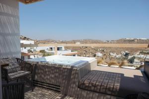 Un balcón con jacuzzi y vista al desierto. en Hotiday Mykonos South Coast, en Mykonos ciudad