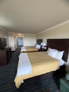 Una habitación de hotel con dos camas y un televisor. en OceanShores Inn, en Ocean Shores 11 fotos más