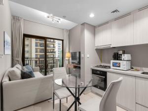 eine Küche und ein Wohnzimmer mit Sofa und Tisch in der Unterkunft Zada Glam Sleek 1BDR Retreat-Business Bay-25 in Dubai