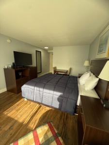 una habitación de hotel con cama y televisor de pantalla plana en OceanShores Inn, en Ocean Shores