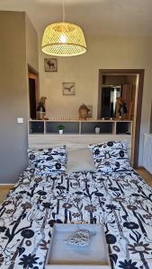 ein Schlafzimmer mit einem Bett mit einer schwarz-weißen Bettdecke in der Unterkunft Gite Suyen, Bain nordique, Sauna in Arrens-Marsous + 37 Fotos