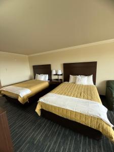 una habitación de hotel con dos camas y un sofá en OceanShores Inn, en Ocean Shores