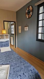 ein Schlafzimmer mit einem Bett und einer Uhr an der Wand in der Unterkunft Gite le tec, Bain nordique, Sauna in Arrens-Marsous