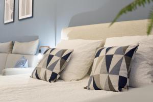 Südstadt-Apartment im Herzen von Paderborn في بادربورن: سرير بوسائد بيضاء وسرير أبيض sidx sidx sidx