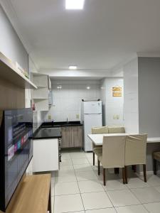 a kitchen with a table and chairs and a refrigerator at Apartamento Centro Capão da Canoa 2 Quadras do mar in Capão da Canoa +8 photos