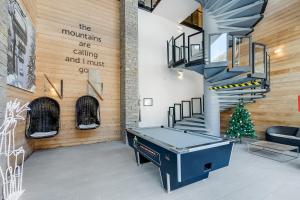 a ping pong table in a room with a staircase at l'Ours Bleu B33 - Ski in Ski out - Happy Rentals in Vallorcine