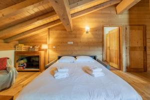 a bed in a wooden room with towels on it at l'Ours Bleu B33 - Ski in Ski out - Happy Rentals in Vallorcine +48 photos