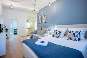 Südstadt-Apartment im Herzen von Paderborn في بادربورن: غرفة نوم زرقاء وبيضاء بسرير واريكة