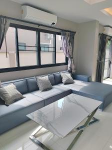 a living room with a blue couch and a glass table at Venice 3 bedroom, 3 bathroom, single family villa in Ban Nong Chaeng