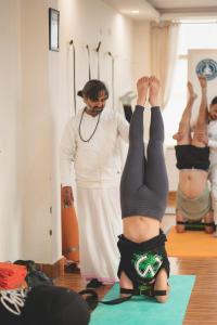een man en twee vrouwen die yoga doen in een kamer bij Hathayogashram Hostel in Rishīkesh