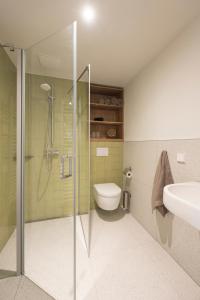 ein Badezimmer mit Dusche, Toilette und Waschbecken in der Unterkunft SEEZIEGE Uckermark - Ferienwohnungen am Carwitzer See in Thomsdorf + 49 Fotos