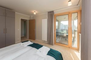 a bedroom with a bed and a large window at SEEZIEGE Uckermark - Ferienwohnungen am Carwitzer See in Thomsdorf +108 photos