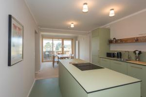 a kitchen with a white counter top and a table at SEEZIEGE Uckermark - Ferienwohnungen am Carwitzer See in Thomsdorf