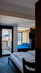 Un dormitorio con una cama grande y un balcón. en Hotel Nassereinerhof, en Sankt Anton am Arlberg