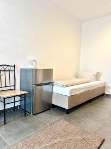 a room with a refrigerator and a bed and a table at Gemütliches Doppelzimmer Gemeinschaftsbad in Dingolfing