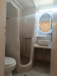 a bathroom with a sink and a toilet and a mirror at Athina Studio Apartments in Kerveli