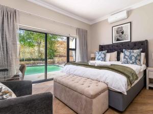 een slaapkamer met een groot bed en een groot raam bij Marang Villa in Kaapstad