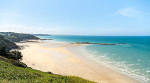 Blick auf einen Strand mit Menschen im Wasser in der Unterkunft Le nid Briochin studio au coeur de Saint-Brieuc in Le Légué