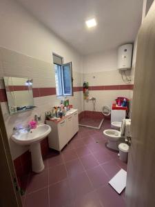 a bathroom with two sinks and a toilet at Villa Hoxha Tepelen in Tepelenë +23 photos