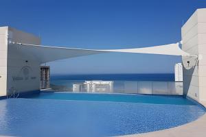 a swimming pool on the roof of a building at Suite moderna cerca del mar in Gaira