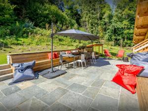拉克吕萨Chalet Riparian - OVO Network的带遮阳伞、桌椅的露台