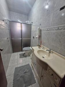 un bagno con doccia, lavandino e WC di Pousada de Muryan a São Gabriel