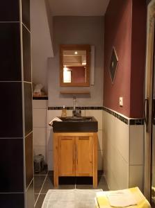 une salle de bains avec un lavabo et un miroir dans l'établissement Gîte Harmony, à Châteauneuf-du-Rhône 21 autres photos