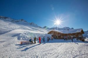 l'Ours Bleu B13 - Ski In Ski Out في فالورسين: مجموعة من الناس تقف في الثلج بالقرب من نزل التزلج