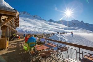 l'Ours Bleu B13 - Ski In Ski Out في فالورسين: مجموعة من الأشخاص يجلسون على منحدر للتزلج