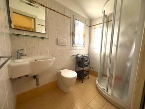un bagno con lavandino, WC e doccia di Comfy villa in central location a Bibione