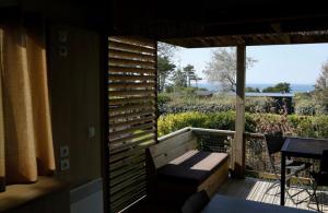 a balcony with a bench and a table on a deck at Chalet 25m2 - Pierres Noires in Plouhinec