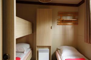 two beds in a small room with two bunk beds at Chalet 25m2 - Pierres Noires in Plouhinec