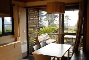 a dining room with a table and a large window at Chalet 25m2 - Pierres Noires in Plouhinec