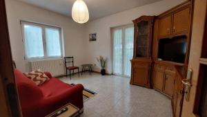 a living room with a red couch and a tv at Al Capitel in Grosotto