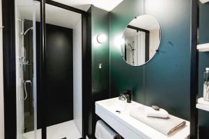 a bathroom with a sink and a mirror at Mobil-home neuf - Au bleu du ciel in Plouhinec
