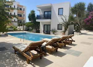 a villa with a swimming pool in front of a building at NAMA Suites in Hersonissos +2 photos