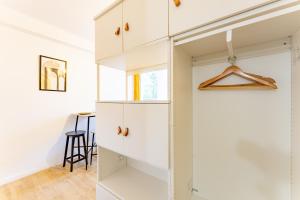 um quarto com um armário com armários brancos em Le charmant Jules Julien parking privé em Toulouse